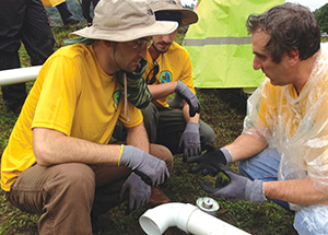 Pitt engineering students Gordon Louderback (left) and Ed Doyle (center) listen as Pitt Engineering Professor Daniel Budny (right) explains how to attach fittings to the end of a PVC pipe. Pitt students were installing the pipes to bring a reliable source of water to residents of Kuna Nega, Panama.