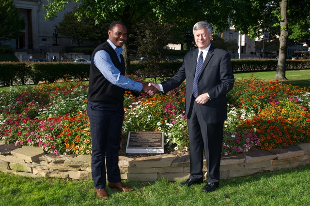 Nicholas Wambua, a Pitt School of Law student and Kenyan native, shakes hands with Chancellor Nordenberg at the dedication of the Wangari Maathai Trees and Garden. 